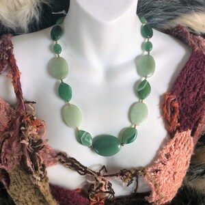 May include: A green agate stone necklace with gold accents. The necklace is made of oval-shaped stones with green and white patterns.
