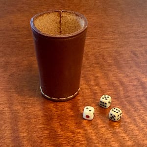May include: A white ceramic mug with a black handle and the text "But first, coffee" in a handwritten style. The mug is on a white surface. The mug is 4 inches tall.