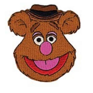 May include: Embroidered patch featuring a brown bear face with a hat. The bear has a pink nose, a red mouth with a pink tongue, and white-rimmed eyes. The hat is brown with a black band. The patch is likely for clothing or accessories.