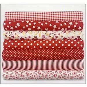 May include: A stack of rolled fabric bolts in various patterns. The fabrics feature red and white gingham, stars, floral, polka dots, and stripes. The color palette is primarily red and white, with a few floral patterns.