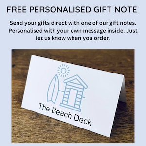 May include: White gift note card with a blue and white illustration of a beach house and surfboard. The text "The Beach Deck" is printed below the illustration.