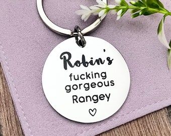 May include: A silver keychain with a round tag that says "Robin's fucking gorgeous Rangey" with a small heart symbol.