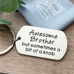 May include: Silver keychain with a tag that reads "Awesome Brother but sometimes a bit of a knob".