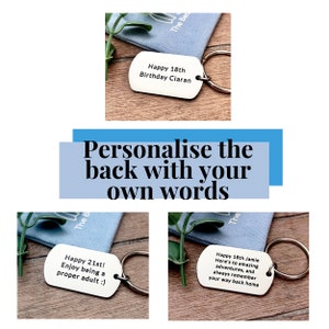 May include: Three silver keychains with personalized messages. The keychains are on a wooden surface with a blue fabric background. The messages on the keychains are: "Happy 18th Birthday Ciaran", "Happy 21st! Enjoy being a proper adult :)", and "Happy 18th Jamie Here's to amazing adventures, and always remember your way back home".