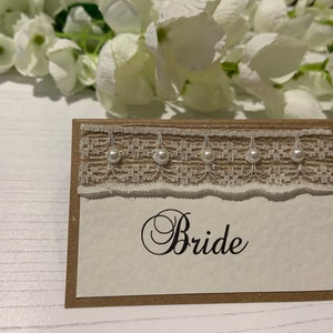 Tarjetas de boda personalizadas con los nombres de sus invitados - Cinta rústica de Hesse con encaje y perlas- Respaldada con tarjeta Kraft