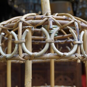 May include: A woven bamboo lampshade with a circular design. The lampshade is made of natural materials and has a rustic look.