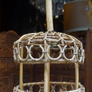 May include: A woven wicker pendant light fixture with a round, open design. The light fixture is made of natural brown wicker and has a simple, rustic style.