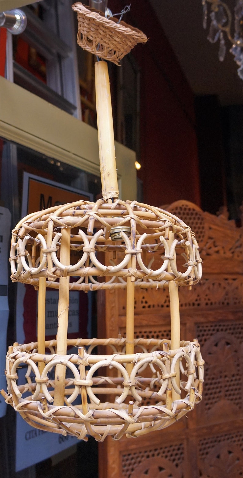 May include: A woven bamboo pendant light fixture with a circular shape and a woven basket on top. The light fixture is hanging from a ceiling.