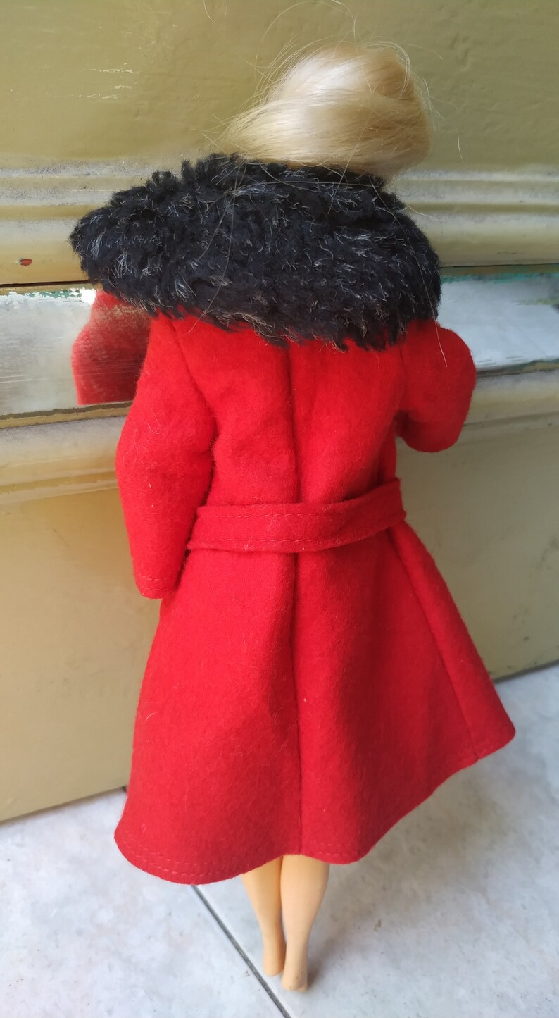 May include: A red coat with a black fur collar. The coat has a belt and is made of a soft, fuzzy fabric.