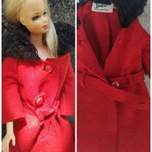 May include: A red coat with a black fur collar and a belt. The coat has two buttons and a label that reads "Barbie by Mattel".