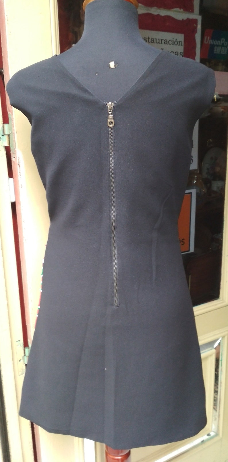 May include: A black sleeveless dress with a zipper down the back.