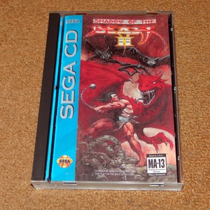 May include: A Sega CD game case for Shadow of the Beast II. The case is blue and features a red dragon with a man fighting it. The game is rated MA-13.
