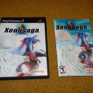 May include: A PlayStation 2 video game case and instruction manual for Xenosaga Episode I: Der Wille zur Macht. The case features a blue and white image of a woman with wings. The manual has a similar image.