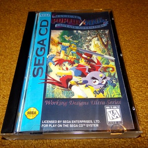 May include: A Sega CD game case with a blue and black background. The game is called "Magical Pop'n'Mail: Fantasy Adventure" and features a colorful illustration of three characters. The text "Working Designs Ultra Series" is printed on the case.