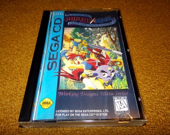May include: A Sega CD game case with a blue and black background. The game is called "Magical Pop'n'Mail: Fantasy Adventure" and features a colorful illustration of three characters. The text "Working Designs Ultra Series" is printed on the case.