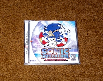 May include: A Sega Dreamcast game case for Sonic Adventure Limited Edition. The cover features Sonic the Hedgehog in a dynamic pose, with the game's title in a stylized font. The case is white with the Sega Dreamcast logo on the side.