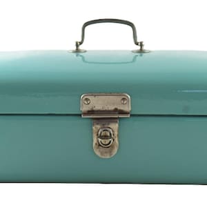 Puede incluir: Una fiambrera vintage de metal color aguamarina con forma rectangular redondeada. Cuenta con un cierre y asa plateados, lo que sugiere un diseño retro. La fiambrera se utiliza probablemente para transportar alimentos y bebidas.