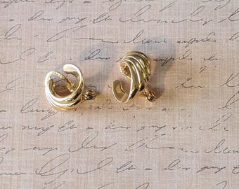 May include: A pair of gold-toned clip-on earrings with a twisted design.