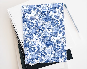 Puede incluir: Un cuaderno azul y blanco con un patrón floral con pavos reales y flores. El cuaderno tiene un fondo blanco con flores y pavos reales azules.