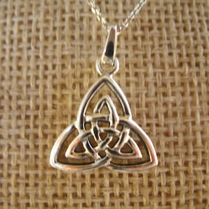 Könnte beinhalten: Silberne Halskette mit einem keltischen Knoten-Anhänger in dreieckiger Form und einem komplizierten Knotenmuster.