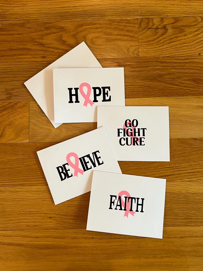 Pode incluir: Quatro cart&otilde;es de felicita&ccedil;&otilde;es retangulares brancos com texto preto e la&ccedil;os cor-de-rosa de consciencializa&ccedil;&atilde;o. Os cart&otilde;es exibem as palavras HOPE, GO FIGHT CURE, BELIEVE e FAITH. Cada cart&atilde;o incorpora um s&iacute;mbolo de la&ccedil;o rosa no design.
