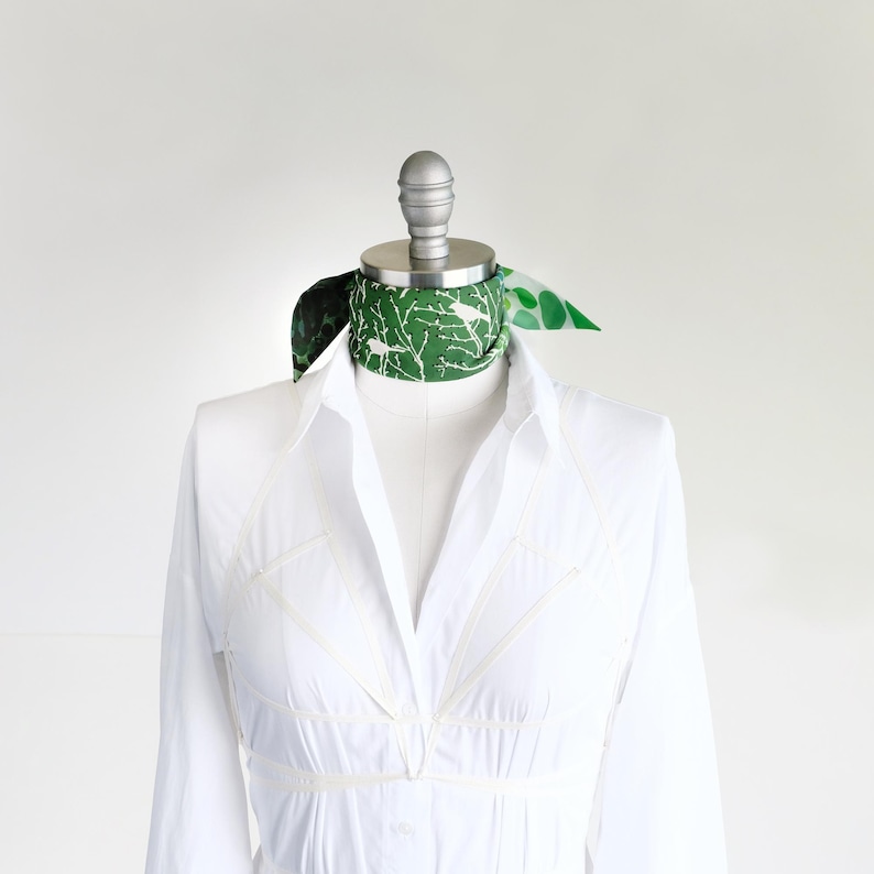 Small soft triangle scarf in a fun medley of green prints. Shown tied as a choker scarf.