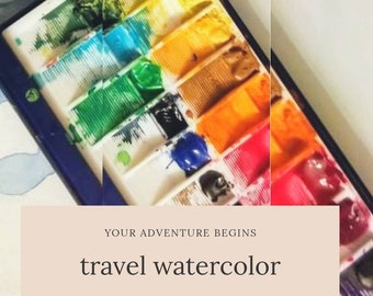 May include: A travel watercolor paint set with 16 wells, filled with vibrant colors including green, blue, orange, and red. The set is in a white and blue container. Text on the image reads "YOUR ADVENTURE BEGINS" and "travel watercolor".