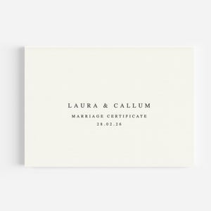 May include: A cream-coloured marriage certificate featuring the names "LAURA & CALLUM" and the text "MARRIAGE CERTIFICATE" in a simple font. The date "28.02.26" is also present. The certificate is rectangular and centrally positioned.