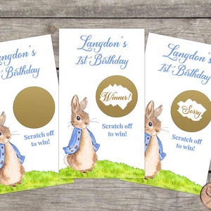 May include: Three white scratch-off cards with a watercolor illustration of a rabbit wearing a blue jacket. The cards have the text "Langdon's 1st Birthday" and "Scratch off to win!" One card says "Winner!" and another says "Sorry."