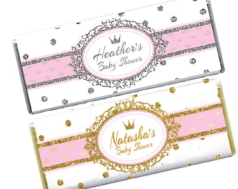Könnte beinhalten: Zwei Schokoladenriegel-Verpackungen mit rosa und weißem Hintergrund. Die Verpackungen zeigen eine goldene oder silberne Krone und den Text "Heather's Baby Shower" und "Natasha's Baby Shower".