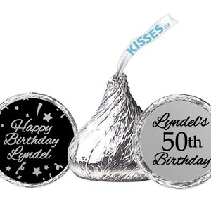 May include: Two silver foil-wrapped chocolate kisses with personalized labels. One label is black with silver text that reads "Happy Birthday Lyndel" with stars and confetti. The other label is silver with black text that reads "Lyndel's 50th Birthday".