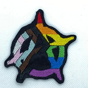 May include: A black embroidered patch with the word "LOVE" in rainbow colours. The letters are stylised and the patch is shaped like a heart.