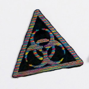 Può includere: Un triangolo nero con un simbolo di rischio biologico al suo interno. Il triangolo è fatto di tessuto a strisce colorate.