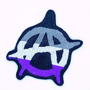 May include: A black and white anarchy symbol patch with a purple, white and grey stripe around the outside. The patch is embroidered and has a rough, distressed look.