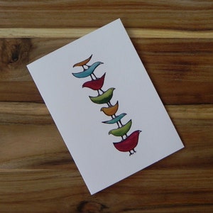 May include: A card with a stack of colorful birds painted on it. The birds are stacked on top of each other, with the bottom bird being red, the next bird being green, the next bird being orange, the next bird being blue, and the top bird being blue.