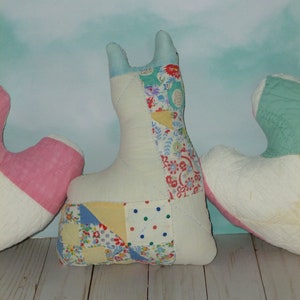 May include: Three patchwork fabric heart-shaped pillows in pink, white, and blue with floral and polka dot patterns.