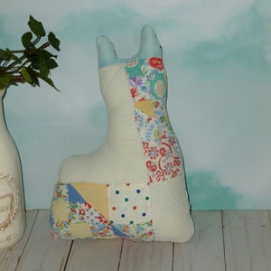May include: A patchwork fabric llama toy with a white base and colorful fabric squares. The llama is standing on a light wood surface.