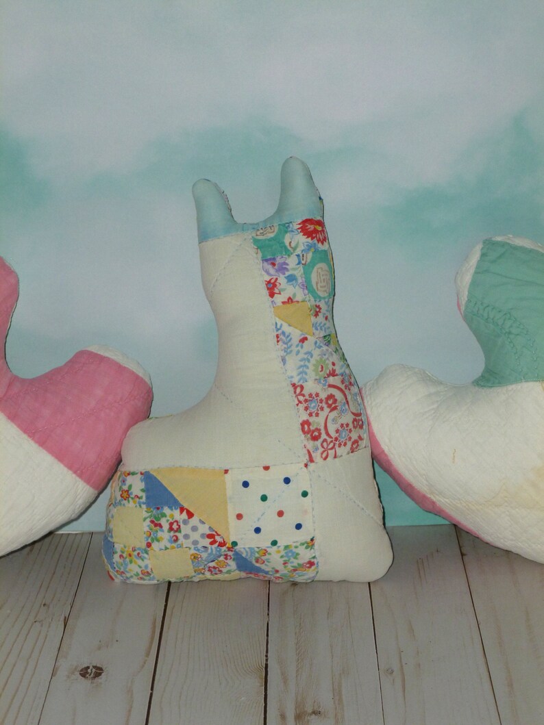 May include: Three patchwork fabric heart-shaped pillows in pink, white, and blue with floral and polka dot patterns.