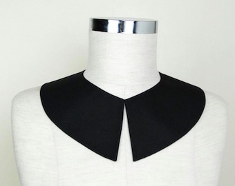 May include: A black fabric collar with a rounded, peter pan style. The collar is on a white mannequin.