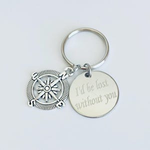May include: Silver compass keychain with a round tag that reads "I'd be lost without you".
