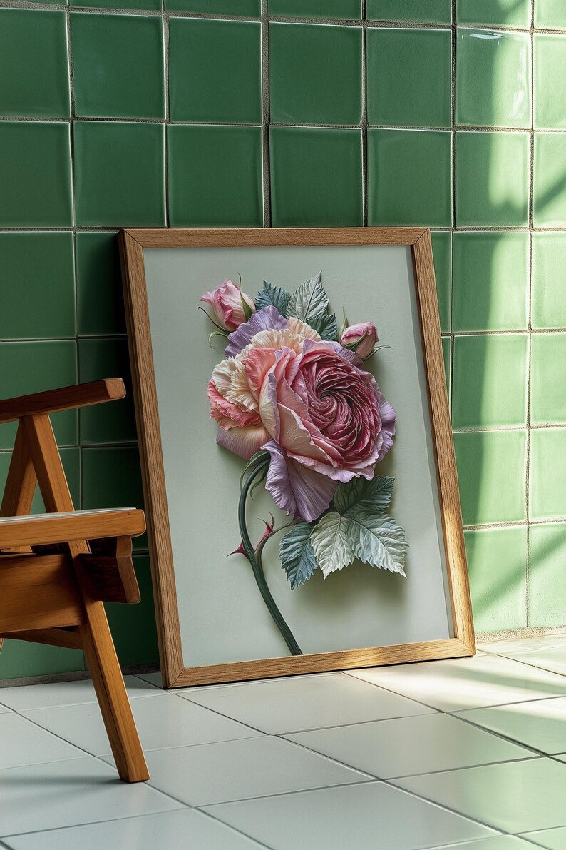 May include: A framed floral art print featuring a large, detailed rose in shades of pink, lavender, and cream. The artwork is set against a light green background and framed in natural wood. The image is leaning against a green tiled wall.