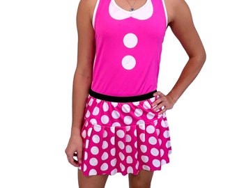 May include: A pink sleeveless top with a white collar and two white buttons. The top is paired with a pink and white polka dot skirt.