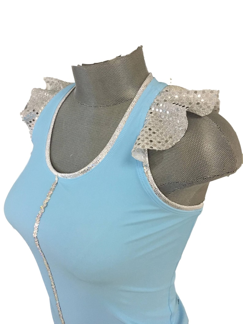 May include: A light blue sleeveless top with silver sequin trim and ruffled sleeves. The top has a scoop neck and a fitted silhouette.