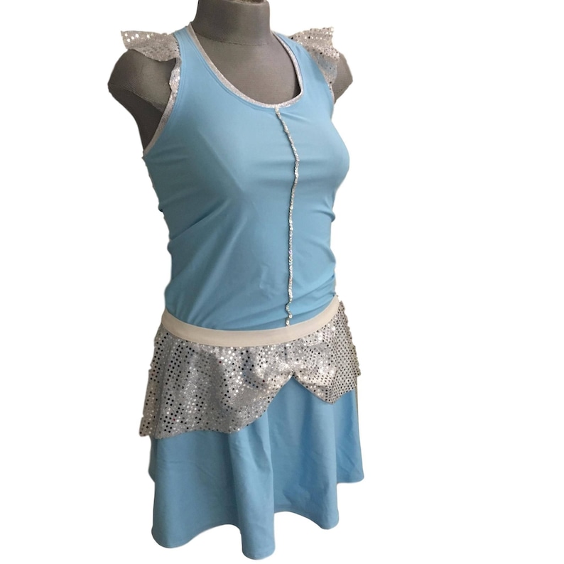May include: A light blue sleeveless dress with a white trim and a silver sequined skirt. The dress has a scoop neck and a fitted bodice.