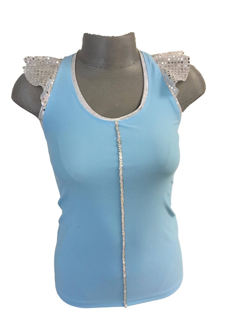 May include: A light blue sleeveless top with a silver trim around the neckline and a silver sequined strip down the center. The top has silver sequined ruffle sleeves.