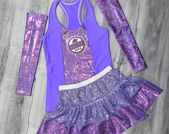 Könnte beinhalten: Lila-weißes Laufoutfit mit einem Traubensoda-Logo auf dem Tanktop. Das Outfit besteht aus einem Tanktop, einem Rock und Armwärmern.