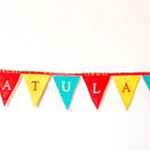 May include: A colorful banner with the word "CONGRATULATIONS" spelled out in yellow, red, and blue triangular flags. The flags are strung together with red string.