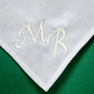 May include: White handkerchief with the word "MR" embroidered in silver thread.