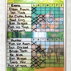 May include: A colorful chore chart with a tiger and elephant image. The chart has a grid with days of the week and a list of chores for two children, Emma and Hunter. Emma's chores include cleaning the room, setting the table, putting clothes away, feeding the dog, eating veggies, picking up toys, and doing homework. Hunter's chores include picking up the room, getting dressed, brushing teeth, being nice, eating veggies, combing hair, and picking up toys.