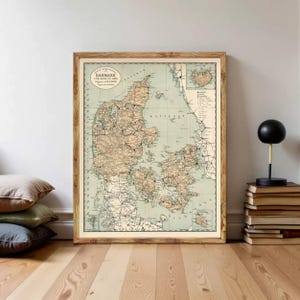 Może przedstawiać: Oprawiona, zabytkowa mapa Danii, z szczegółową kartografią w odcieniach sepii na jasnym, zielonym tle. Mapa jest w drewnianej ramie i zawiera tekst w lewym górnym rogu. Całość utrzymana w stylu antycznym.